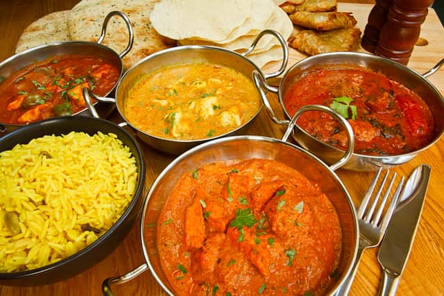 Selection of Indian food with pilau rice, naan bread, poppadoms.
