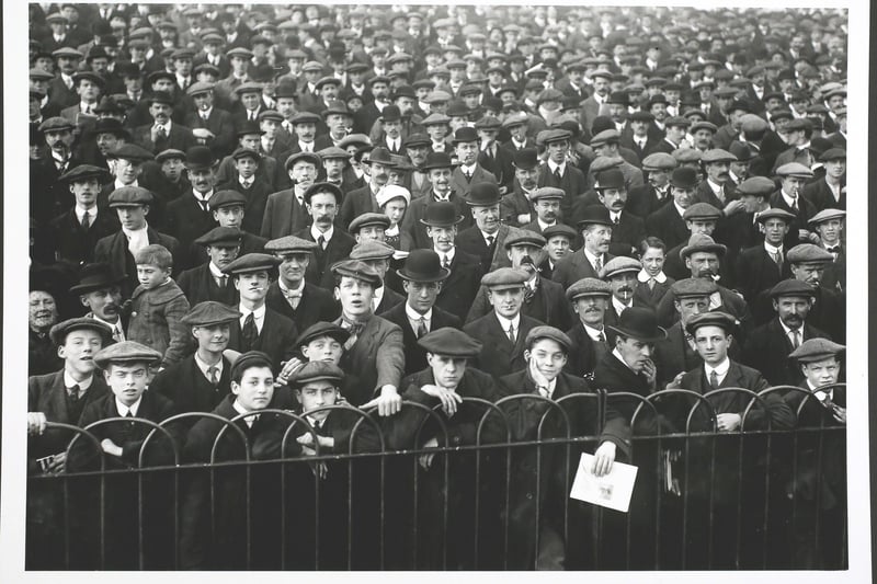Hats And Caps. A crowd gathers at Highbury Stadium in London to watch Arsenal play a home match against Nottingham Forest.